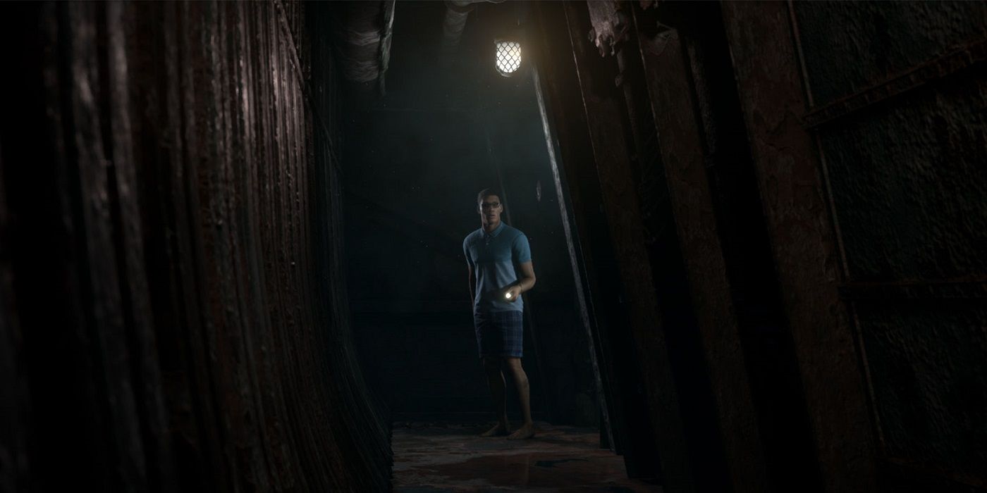 Alex looking down a long dark corridor, pointing his flashlight forward.