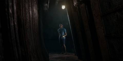 Alex looking down a long dark corridor, pointing his flashlight forward.