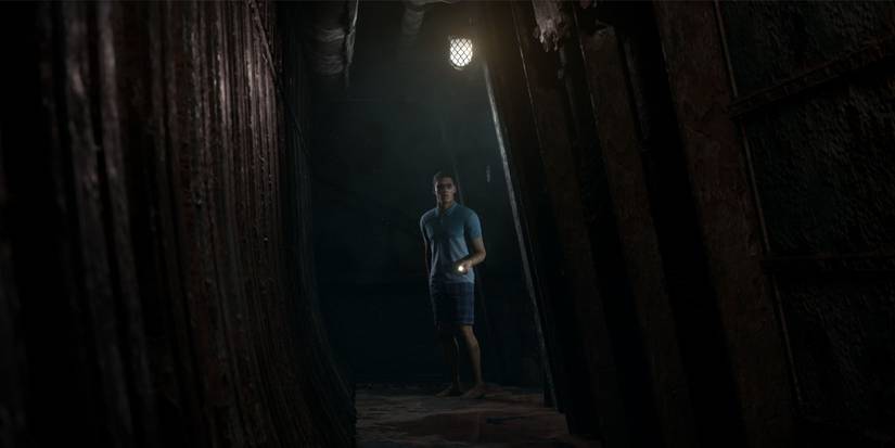 Alex looking down a long dark corridor, pointing his flashlight forward.