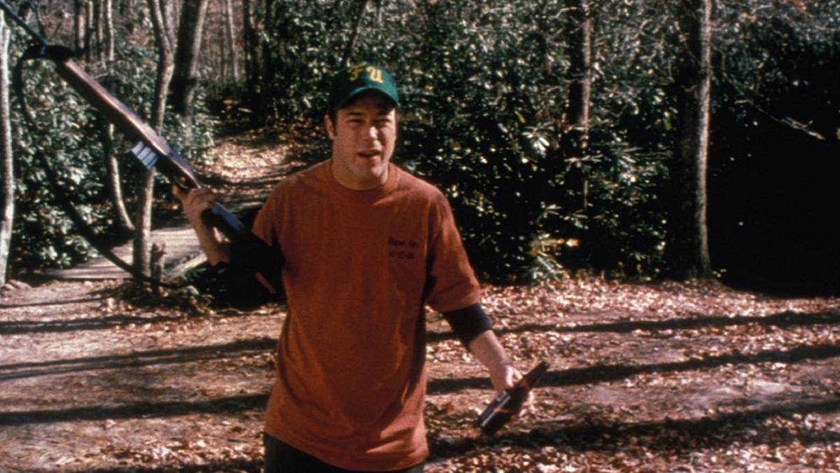Man in the woods holding a rifle and beer