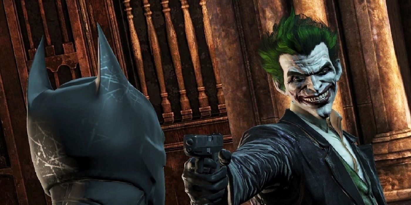 joker holding gun to batman