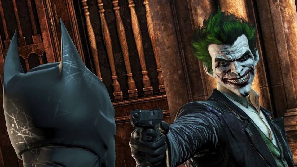 joker holding gun to batman