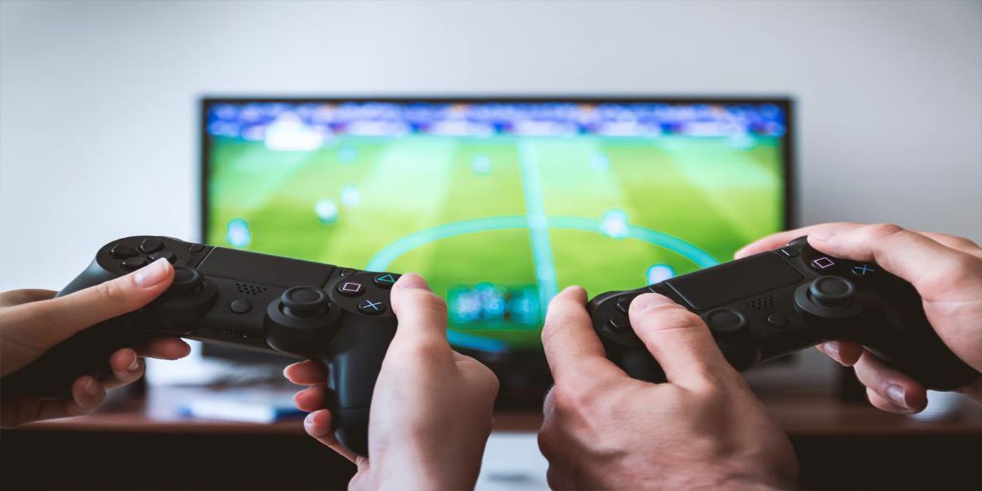 Hands holding PS4 controllers playing Soccer game