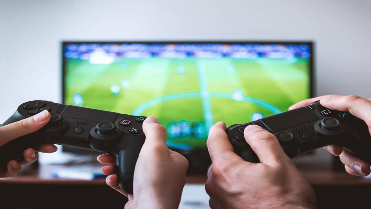 Hands holding PS4 controllers playing Soccer game