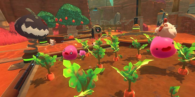 A carrot field with pink slimes getting attacked by tarr monsters in Slime Rancher