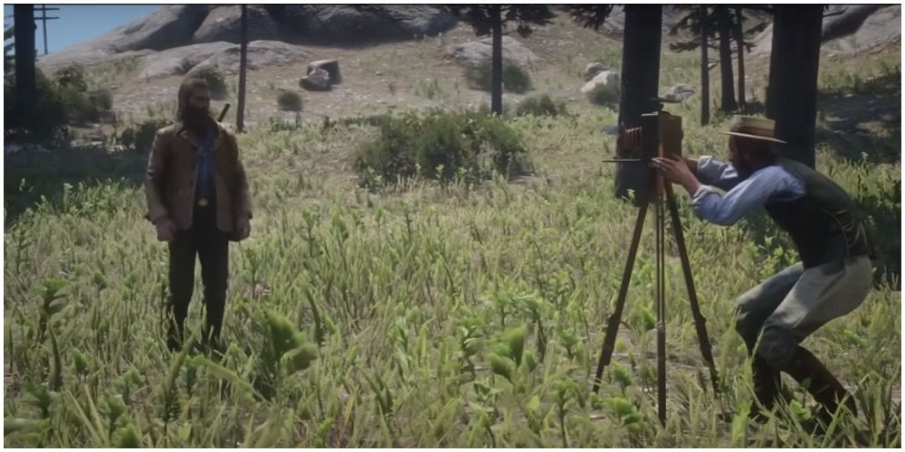 Albert Mason setting up his camera near Arthur in Red Dead Redemption 2