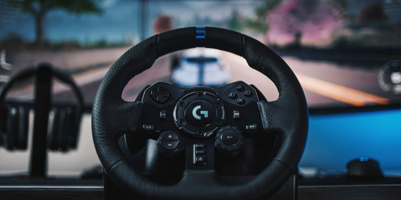 A Logitech G923 steering wheel sits in front of a computer screen playing a racing game.