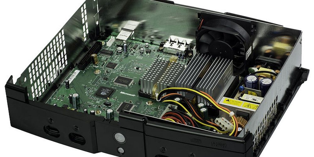 The Inside Of An Original Xbox Showcasing It's Motherboard And PCU.