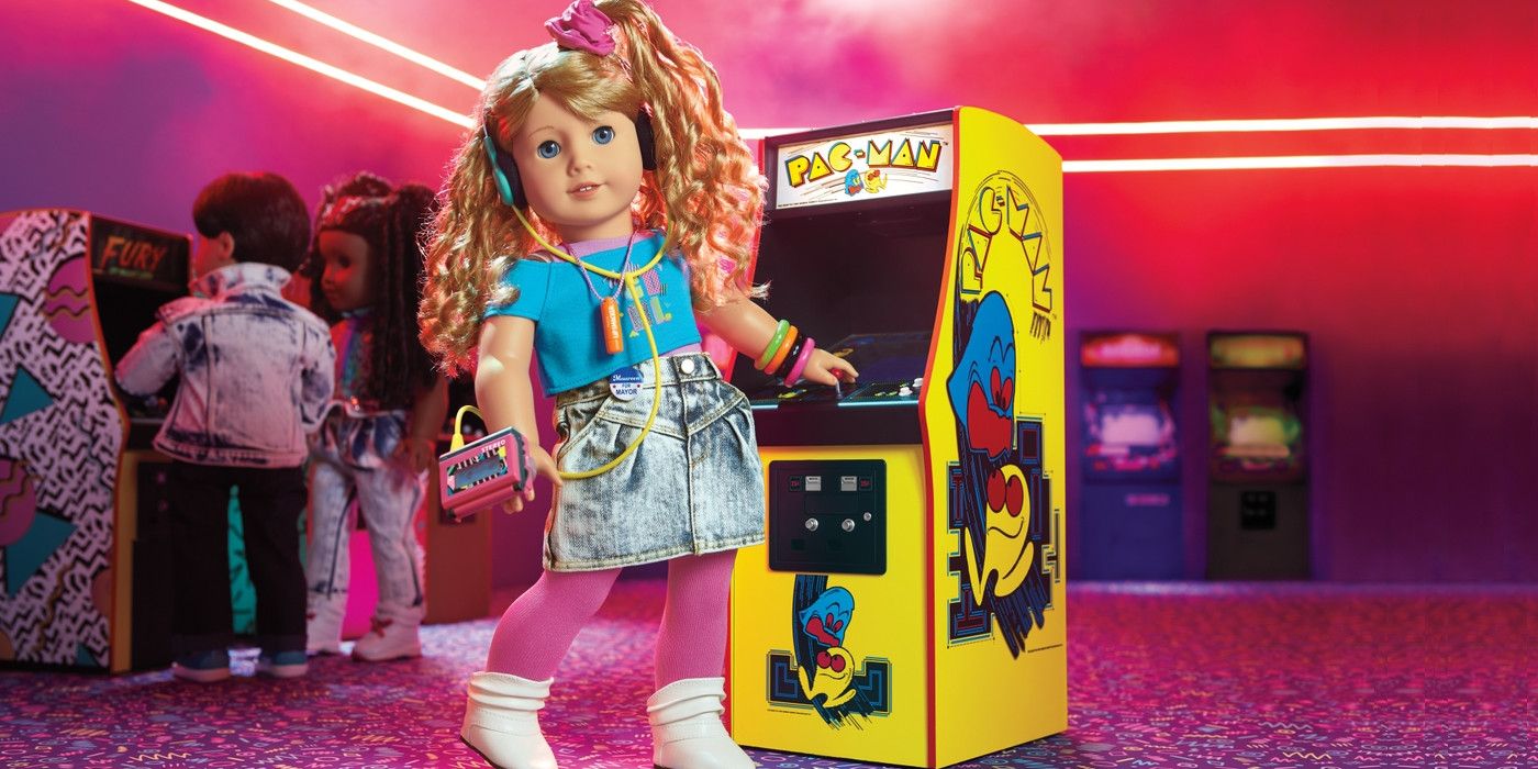 American Girl doll Courtney Moore stands next to a Pac-Man arcade cabinet.