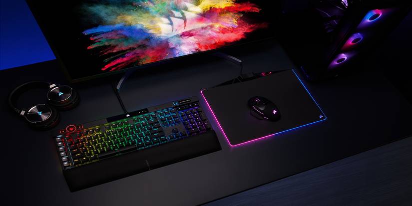 Corsair K100 keyboard resting on a desk next to a mouse