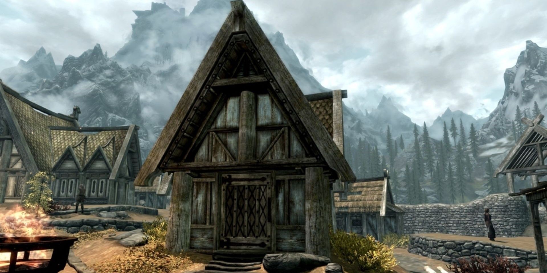 A small skyrim house with mountains in the background