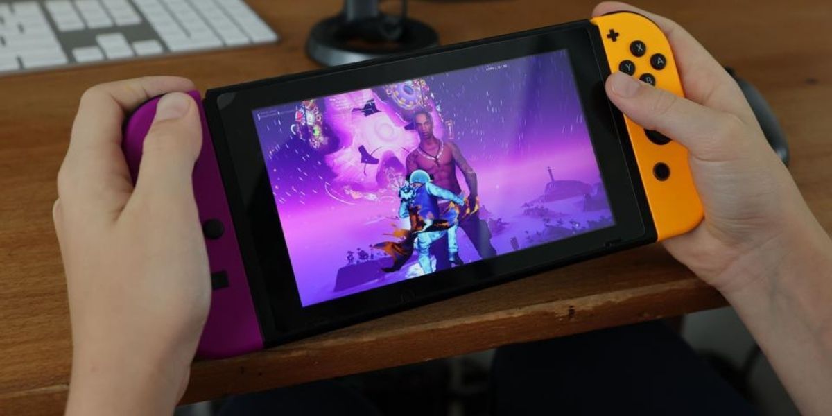 Nintendo switch console being shown off with purple and orange joycons