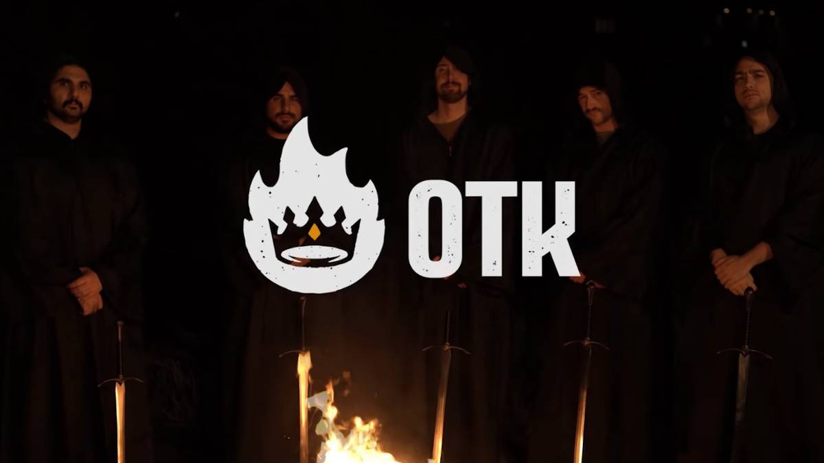 The five founders of OTK stand around a campfire, wearing hooded robes and wielding swords.