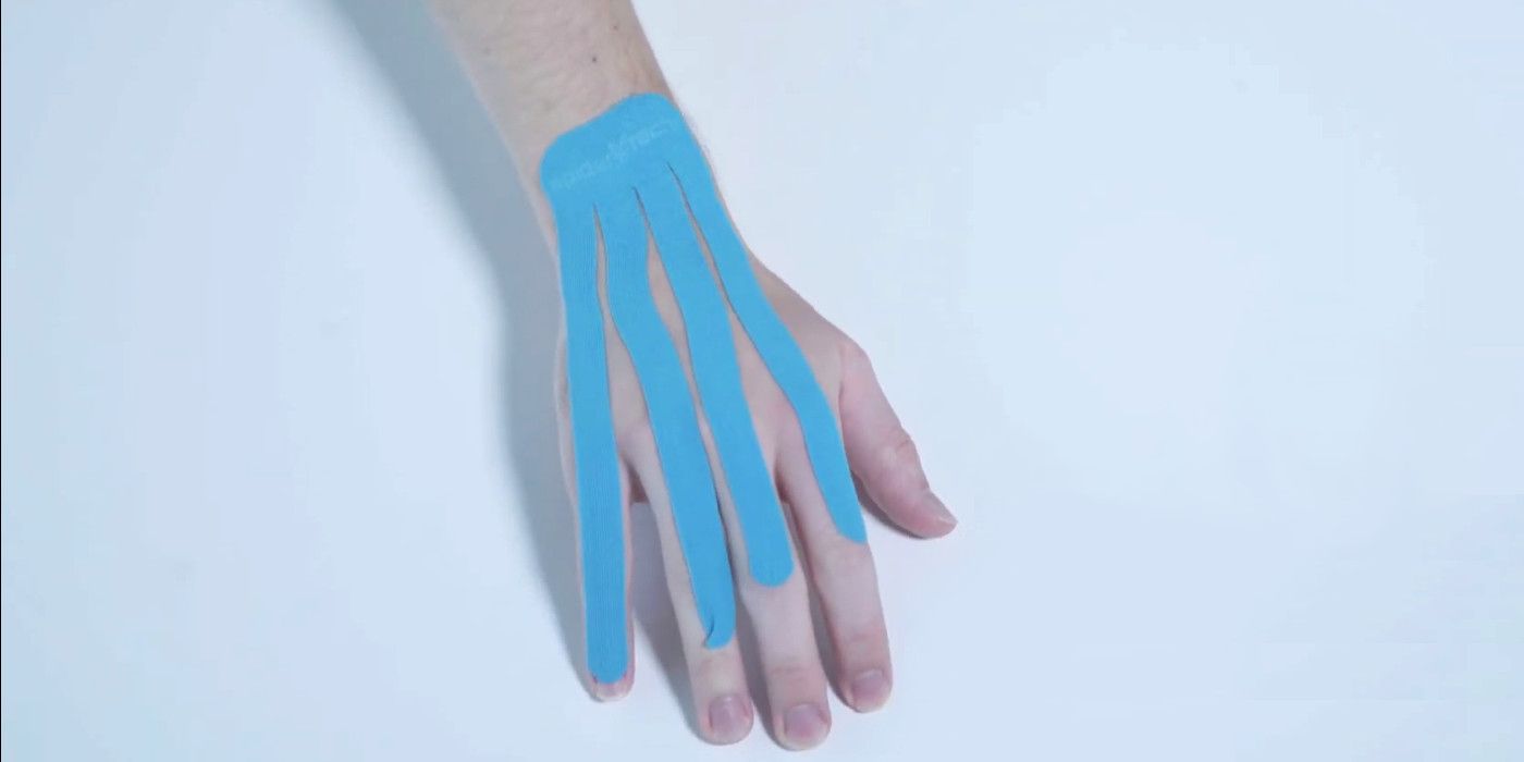 A blue fan of kinesiology tape, applied to the back of a hand.