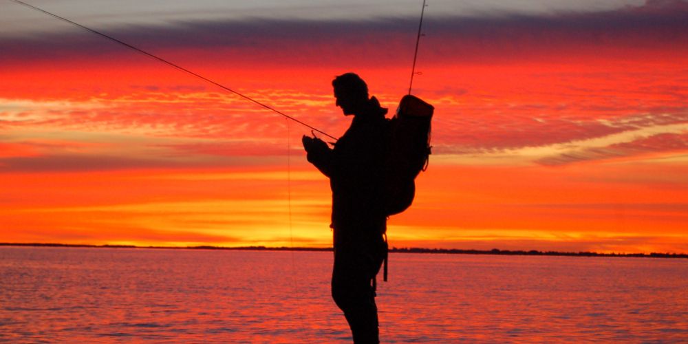 silhouette of a man fishing