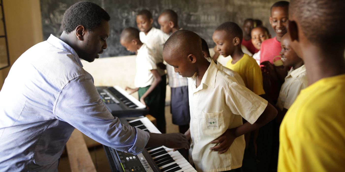 A teacher from the Playing for Change Foundation shows students how to play music on a keyboard.