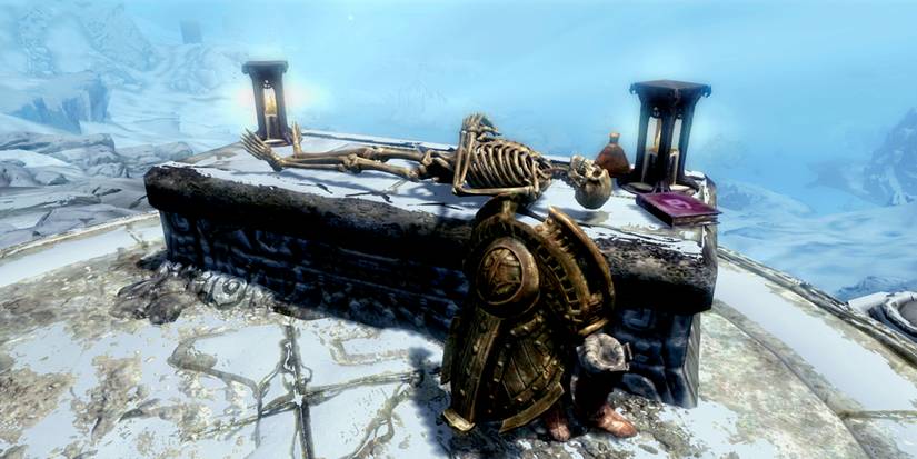 skeleton and some loot by an altar on a cliff