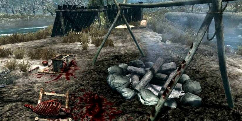 bloody campsite with bones near a fire pit