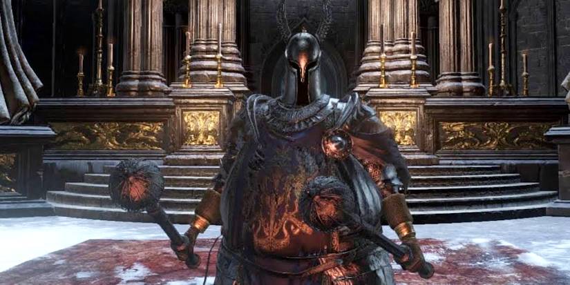 player in heavy armor holding two round headed hammers