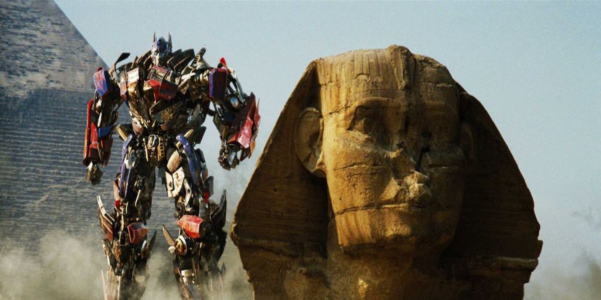 optimus emerging from behind a pyramid after defeating megatron and the fallen