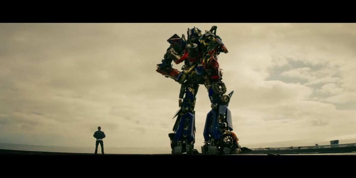 optimus prime and sam standing on an aircraft carrier