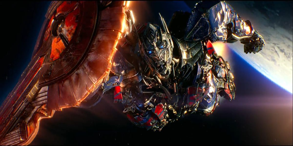 optimus prime flying out of earth with his shield out in front of him