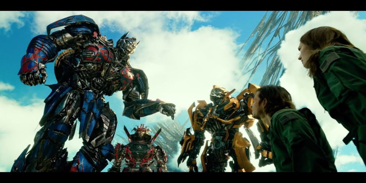 optimus prime giving his speech while surrounded by autobots and humans