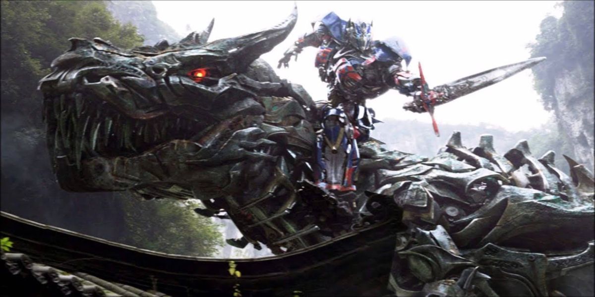 optimus sitting on a t-rex dinobot