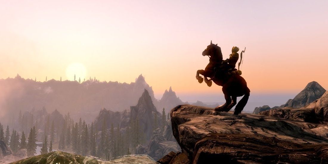 A horse bucks on a cliff at sunset