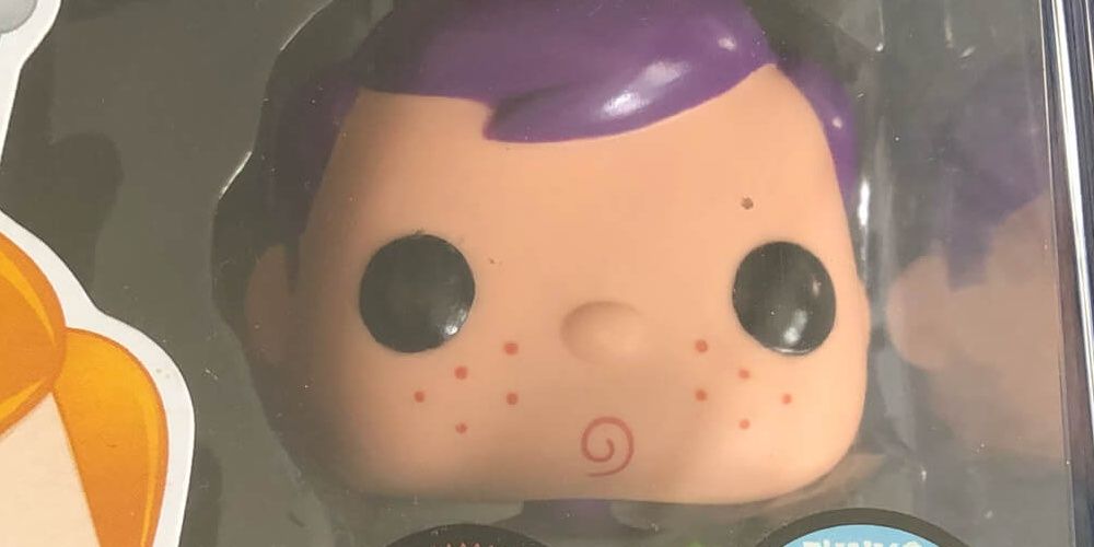 Purple-haired Freddy Funko still in mint packaging, with spiraling lip expression.