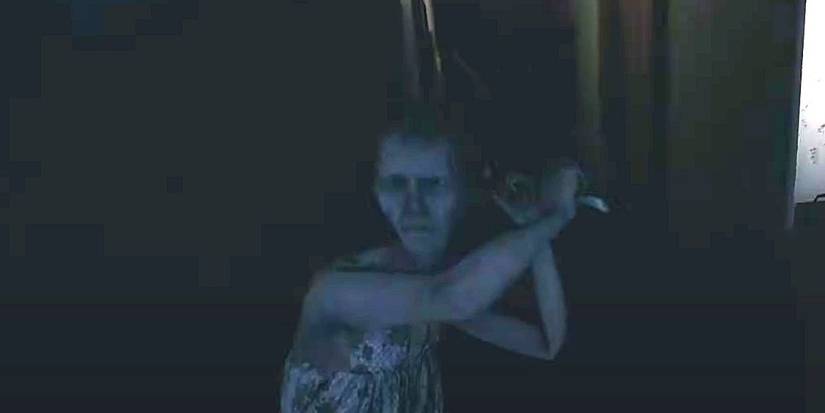 An elderly woman swings a sledgehammer