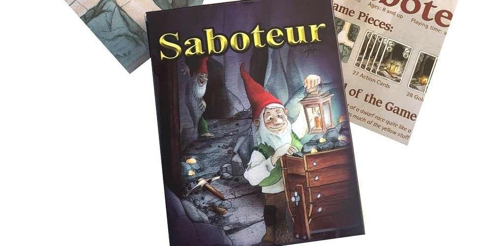 Saboteur game box with tunnel piece to its left, and instructions on its right.