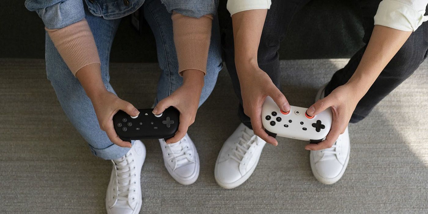 Hands shown holding two Google Stadia controllers