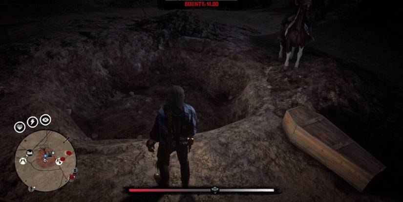 John Marston standing over a mass grave in Armadillo in Red Dead Redemption 2