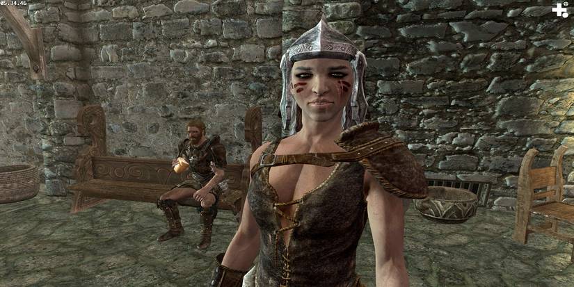 Skyrim Njada Stonearm Inside Jorvaskkr Companion Sitting On Bench Eating Bread Behind Her