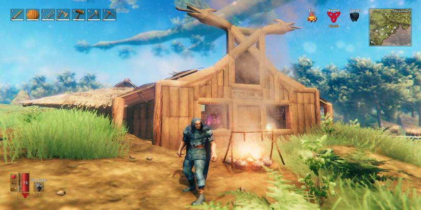 A warrior in a blue cloak stands outside a building with items in the window