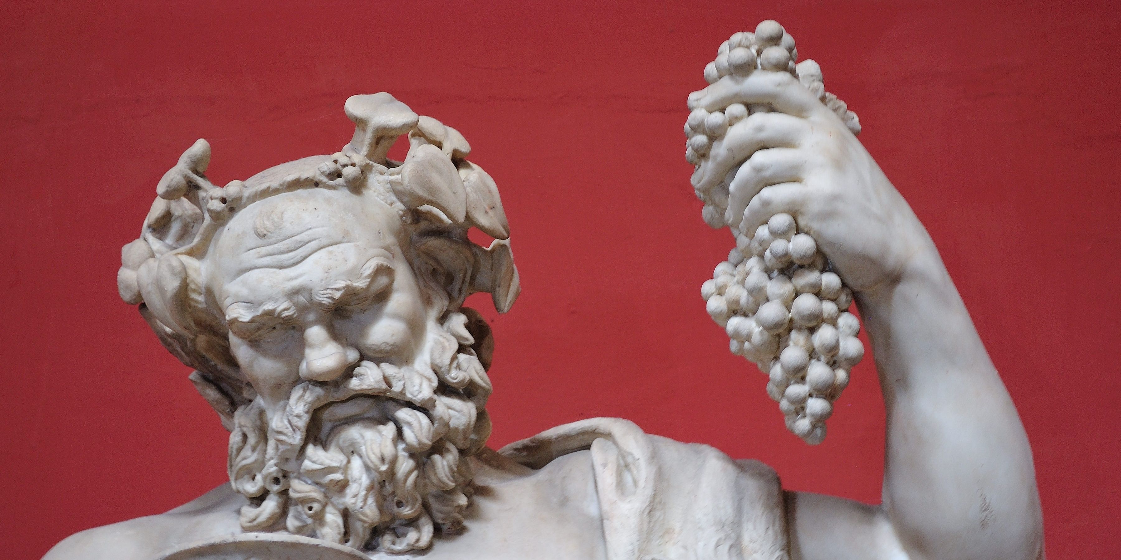 A statue of Dionysus holding grapes