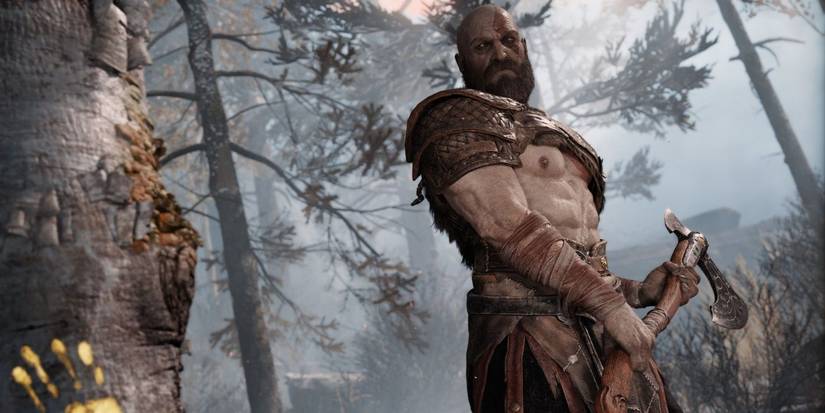 god of war kratos looks at tree axe in hand