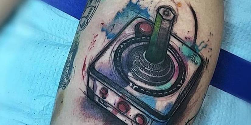Atari joystick leg tattoo with water color splashes.