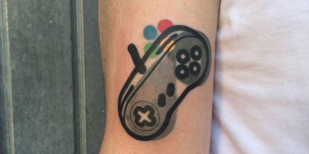 Minimalist Super Nintendo tattoo on bicep.