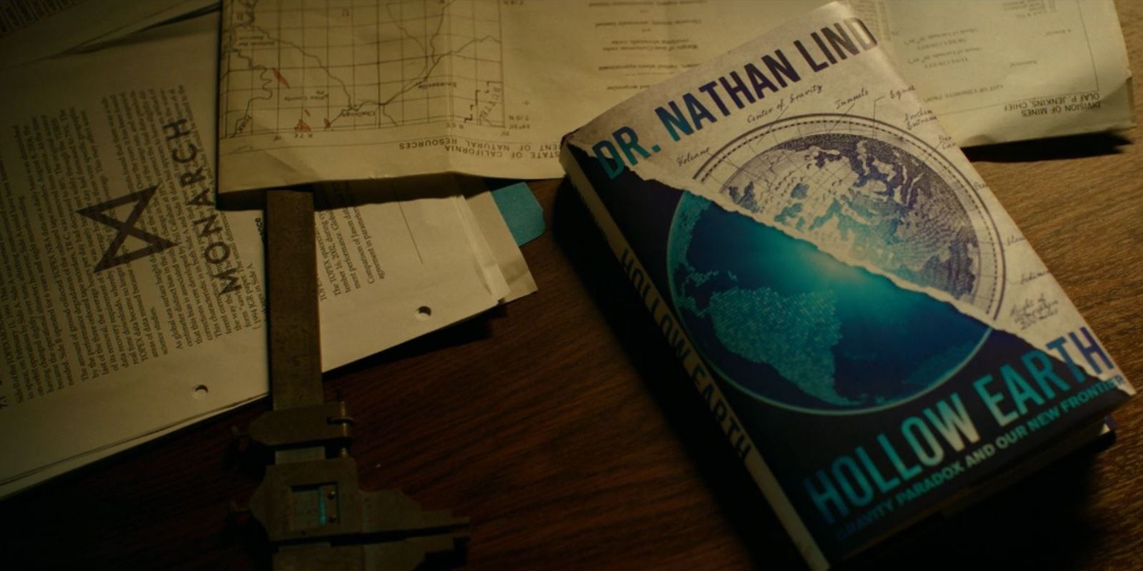 A desk bearing Nathan Lind's book "Hollow Earth"