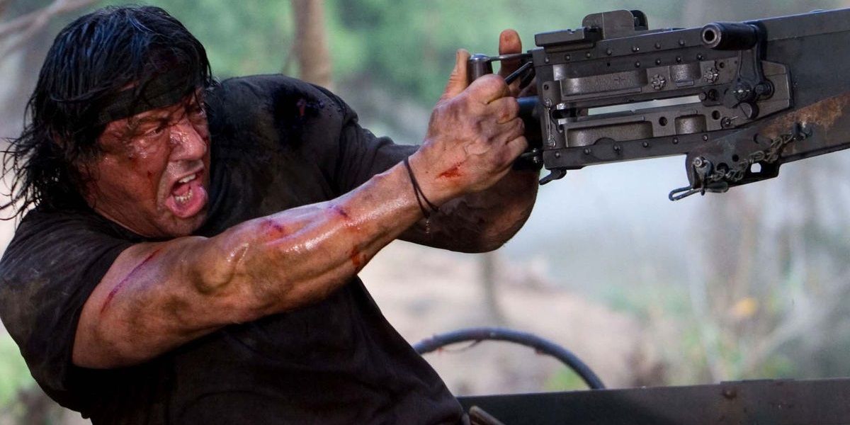 Sylvester Stallone as John Rambo mounting a giant machine gun