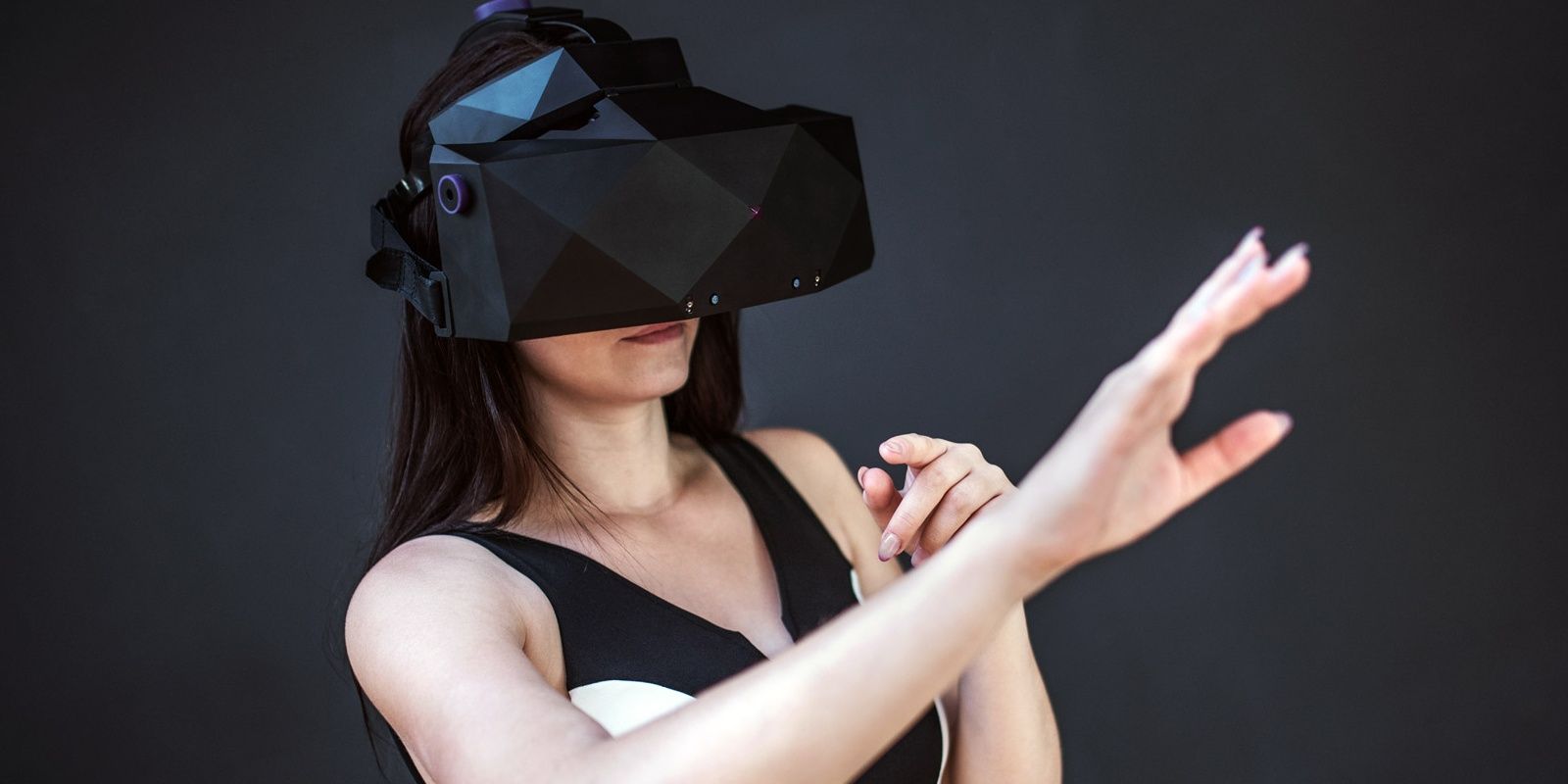 Woman with VR headset reaching her hand out