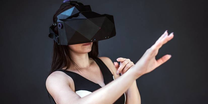 Woman with VR headset reaching her hand out