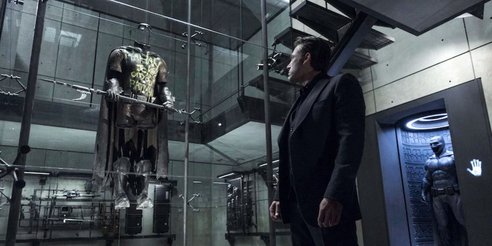 bruce wayne looks at robin suit in the batcave in batman v superman