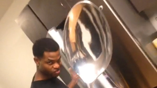 A black teen holds up a comically giant tablespoon