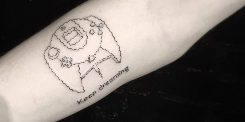 Line art tattoo of sega dreamcast controller with the words "Keep Dreaming.".