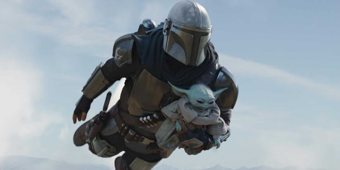 Din Djarin from the Mandalorian flying with a jetpack carrying Baby Yoda/Grogu