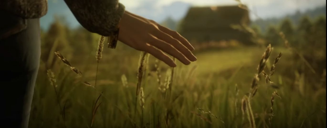 Selene runs her hand in a field of grass outside of her home on Earth