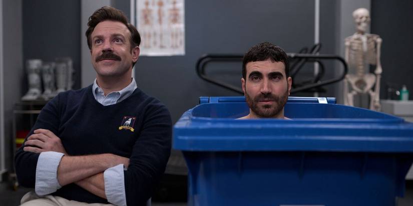 Lasso standing next to a man in a trash can